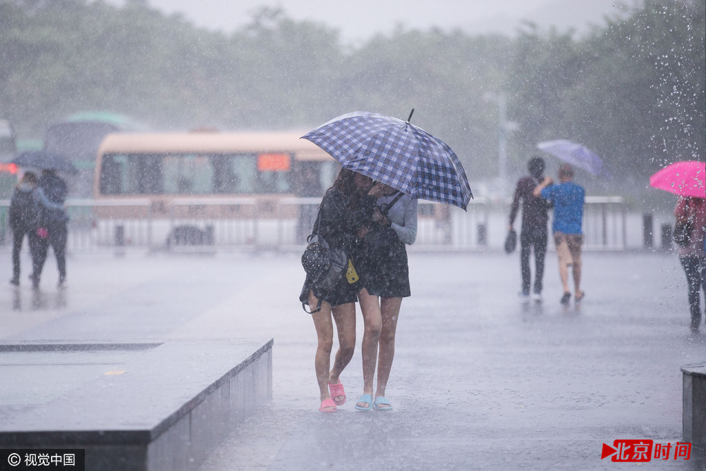 2016年10月21日，广东省深圳市，受今年第22号台风“海马”影响，深圳市区狂风暴雨，市民撑伞“艰难”前行。