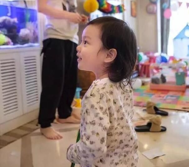 从另一个角度看,小甜馨抱着紫色的小兔子玩偶在阳台上,妥妥的小公举啊