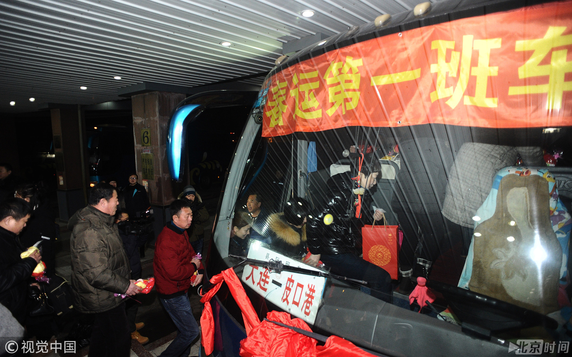 与此同时，汽车客运也拉开春运帷幕。图为2018年2月1日，在大连交运集团北岗桥汽车客运站，旅客乘坐该站春运首发班车出行。