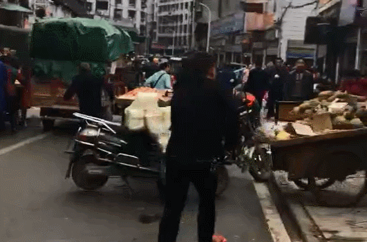 水果商贩占道经营 红袖章男子抡大锤猛砸菠萝摊
