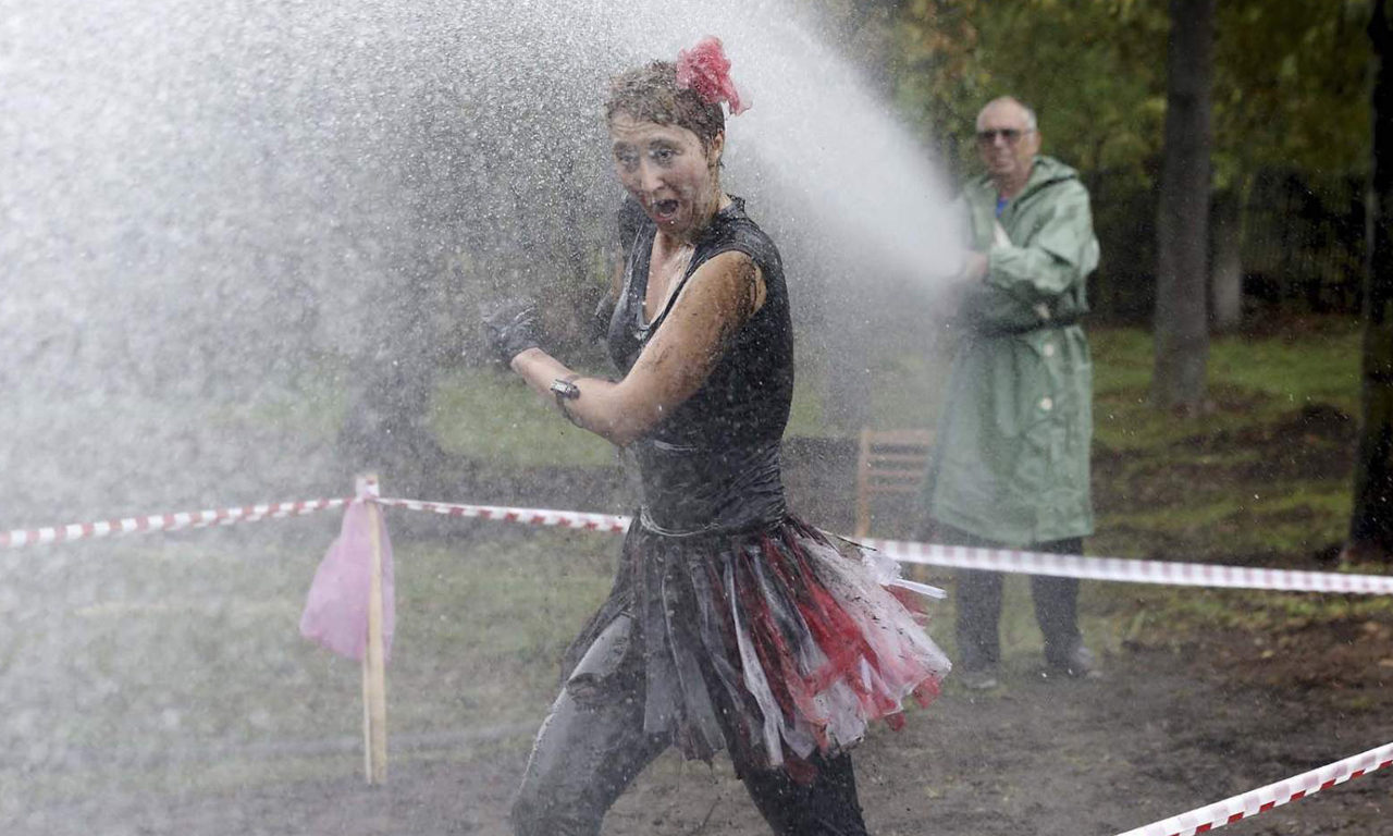因此不管你的身体状况如何，那里总有一个适合你目前健身水平的障碍赛内容。图为主办方为选手冲洗身上的泥。