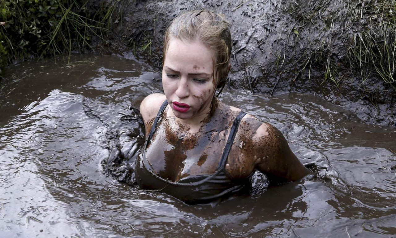 极限障碍跑是一项由特种兵设计的挑战人类极限的赛事，比赛内容极为惨烈、苛刻。图为某美女选手陷入泥潭。