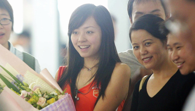 张靓颖的父亲在她15岁的时候病逝了,妈妈的身体不好,从小就喜欢唱歌的张靓颖便主动要求到酒吧里唱歌,为妈妈减轻负担。她在一个叫“成都音乐房子”的酒吧里唱一晚上3首歌大概200元,专唱英文歌,偶尔唱唱法文和西班牙语歌曲,从没受过专业训练,但是喜欢玛利亚·凯瑞的她无师自通,一副漂亮的嗓子让许多同行羡慕不已。2005年超女期间,张靓颖认识了冯轲。冯轲极力支持张靓颖,动用自己的一切资源为张靓颖四处拉票、请粉丝。夺得超女季军后,母亲与冯轲成了张靓颖的左膀右臂,母亲时常陪在她身边参加活动,冯轲则是他“背后的男人”。图为2005年8月,张靓颖在妈妈歌迷陪同下从长沙回重庆。