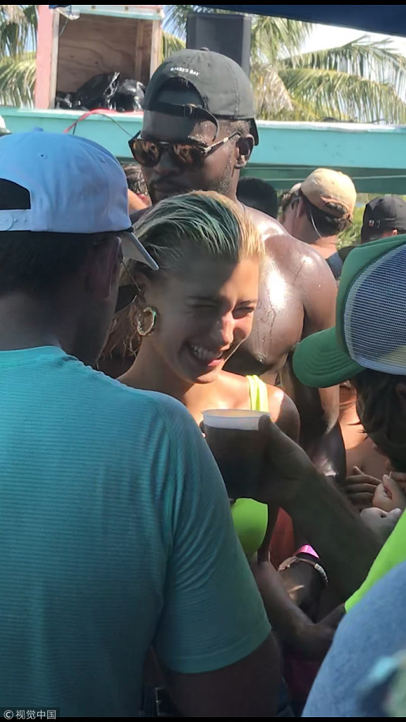 当地时间2018年7月9日，巴哈马，贾斯汀·比伯（Justin Bieber）和海莉·鲍德温（Hailey Baldwin）在海滩庆祝他们订婚。比伯赤裸上身露纹身，和海莉·鲍德温在人群中热吻，高调示爱。海莉·鲍德温激动飙泪。