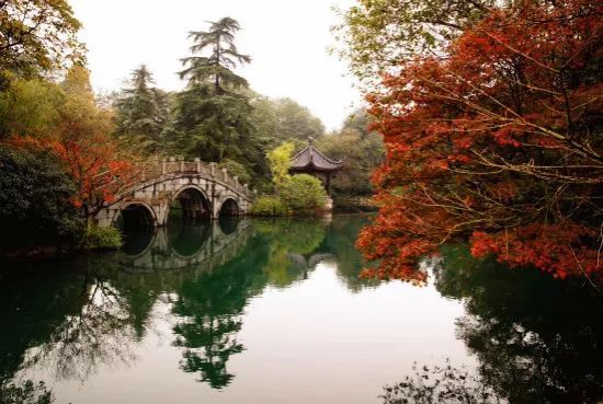 绾波亭依湖而建,掩映在绿丛之中.亭旁拱桥横卧碧波,静静相守.