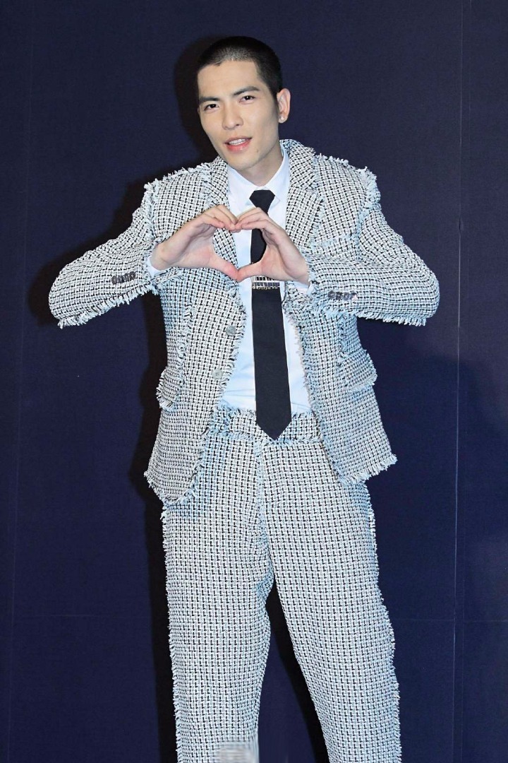 萧敬腾的搞怪表情一向都是镜头中的亮点，用手比出心的样子代表着对新人的祝福。