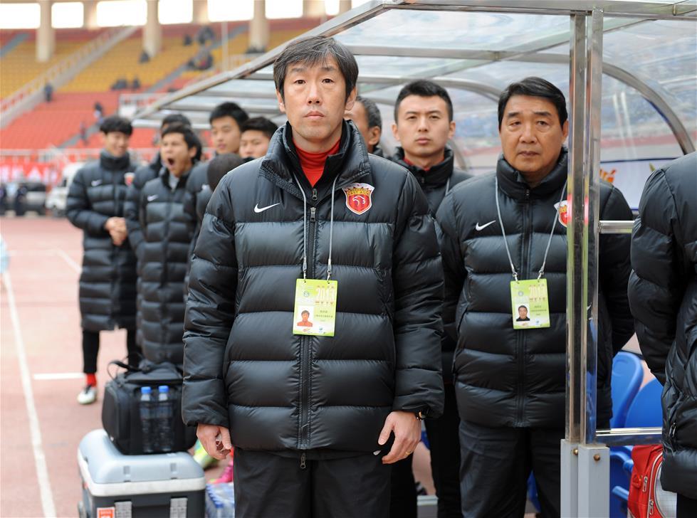 图为2013年3月30日，时任上海东亚队主教练的高洪波（前）在场边等待中超联赛第三轮上海东亚队对阵大连阿尔滨队比赛开始。