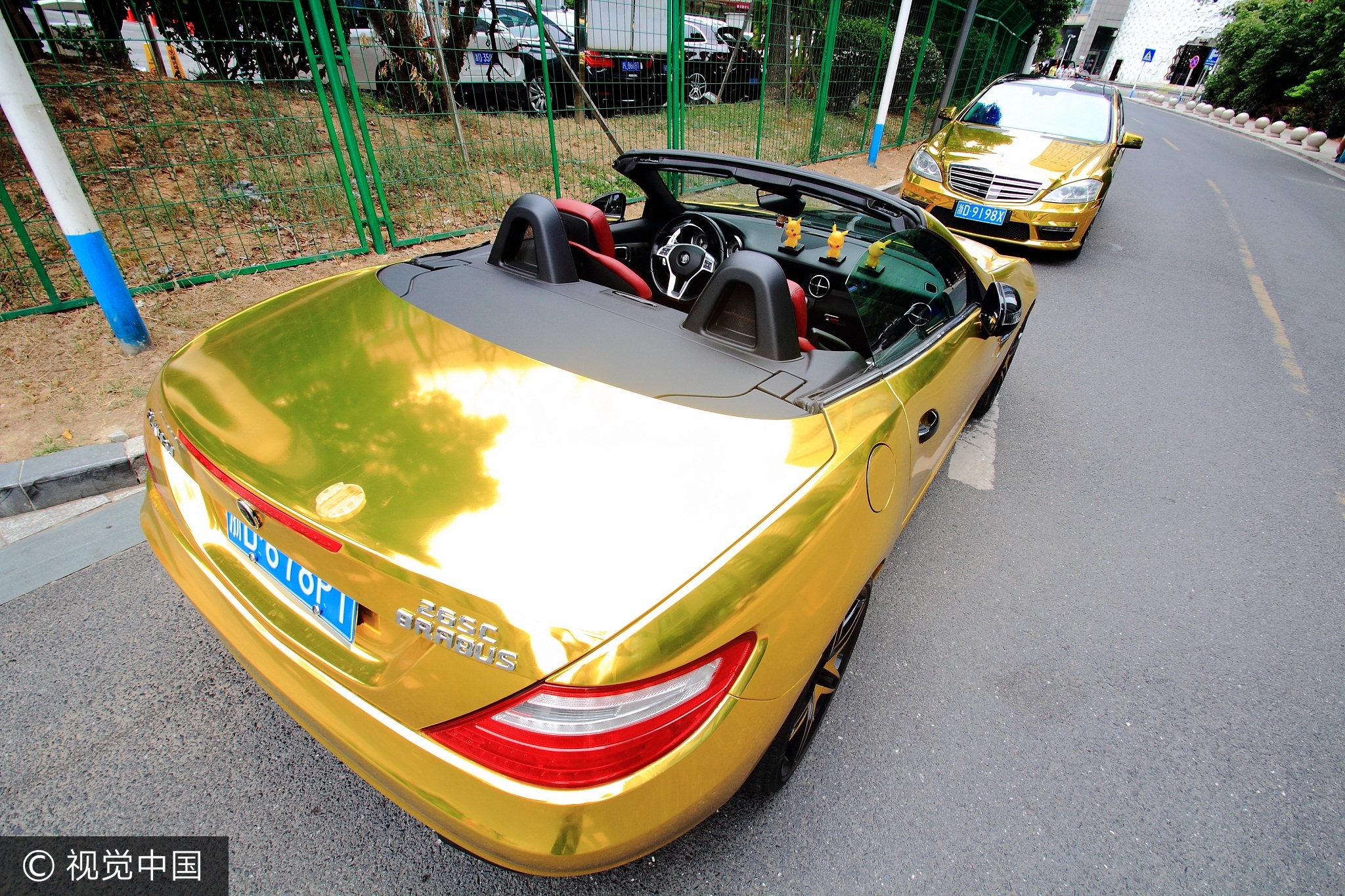 这两辆跑车发出闪闪金光，吸引了无数市民的目光。