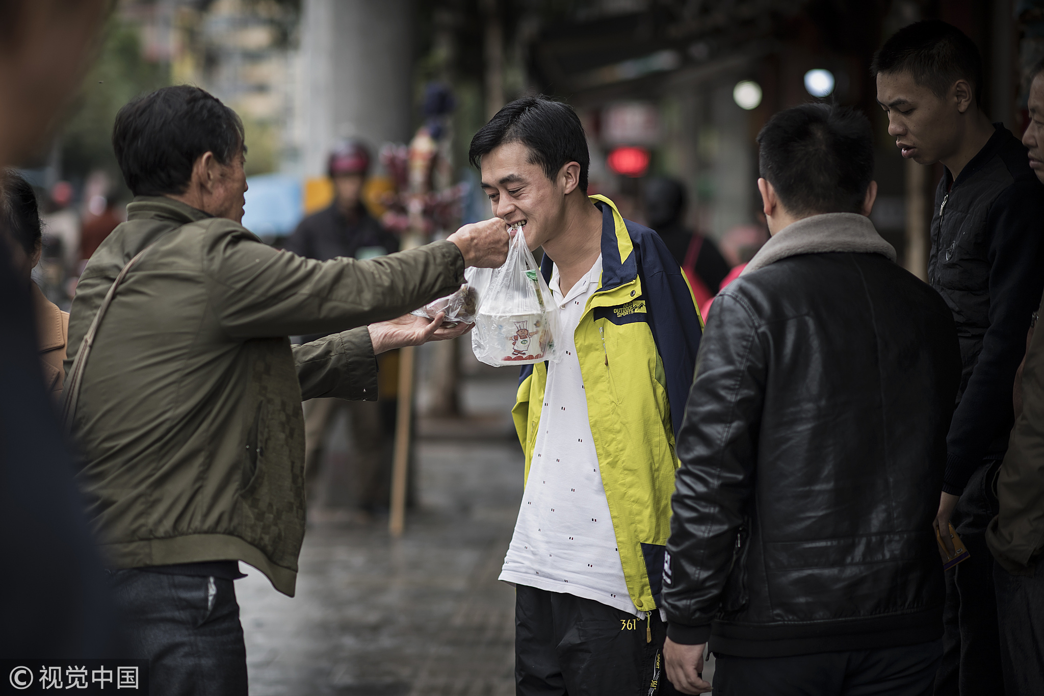 长大后，他不想成为一个“闲人”，凭着一股不服输的劲头，陈兹方还可以锄地干活，成了家里的主要劳动力。哥哥成家后，他与母亲相依为命。图为2018年10月20日，湖北恩施，陈兹方在街上为母亲买饭，总是有人对他嘘寒问暖，有的还送他东西。