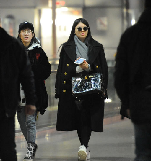 近日李湘抵达上海虹桥机场,当天李湘手挽名牌包出现,虽然一身黑装却
