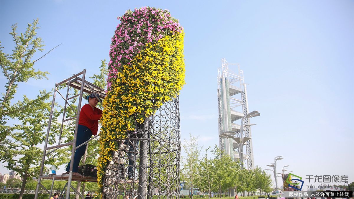 4月27日,工人们在北京奥林匹克公园内加紧布置花柱。迎接即将在北京召开的“一带一路”国际合作高峰论坛(图片来源:tuku.qianlong.com)。千龙网记者 陈健男摄