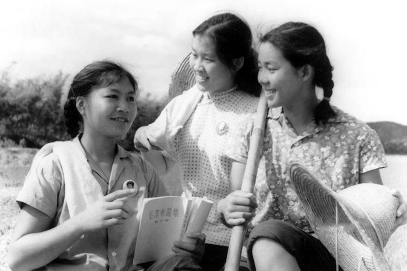 她穿着绿军装、戴军帽，胳膊上还系着毛泽东思想宣传队的红袖章，脸上带着发自内心的笑容。这是1966年10月18日，她在天安门广场跳“忠字舞”。六七十年代，全国人都穿得极其单调，“蓝灰黑”一统天下，中国女人也一样。