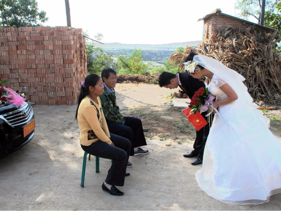 2009年耀州区演池乡，在院子里新郎新娘向父母鞠躬，母亲应该很舍不得女儿，但是男大当婚女大当嫁是必然的。图片来源：姚忠智/视觉中国