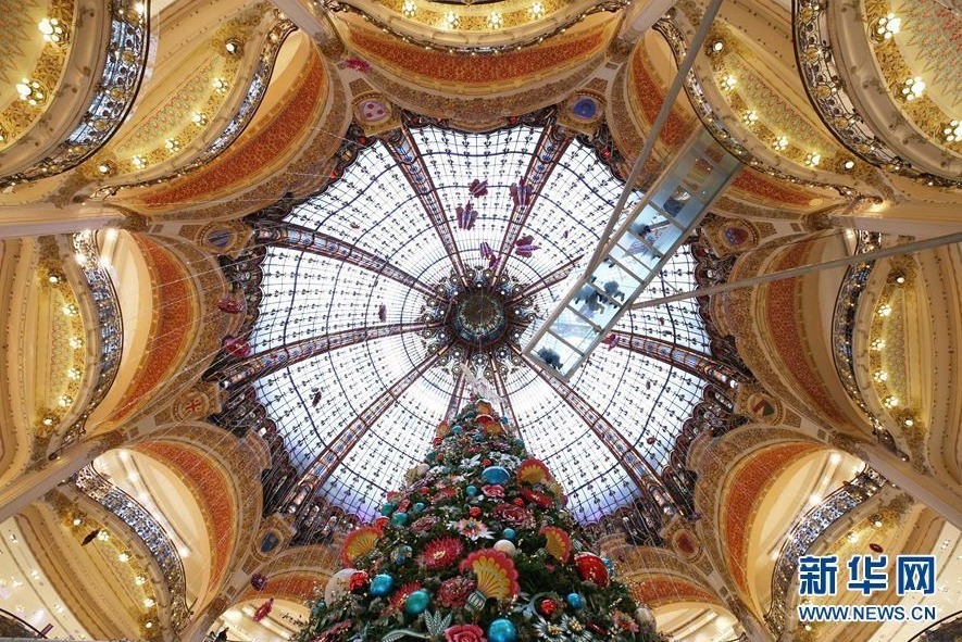  近日，法国巴黎老佛爷百货公司立起巨型圣诞树，璀璨的灯光和精美的造型设计吸引了众多市民和游客前来参观。人们还可以在商场三楼处踏上高16米、长8米的玻璃走廊，与圣诞树“亲密接触”。