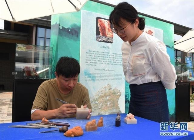 6月13日，游客在“福建日”活动中了解寿山石雕制作。 当日，2019年中国北京世界园艺博览会“福建日”活动在北京世园会园区举行。