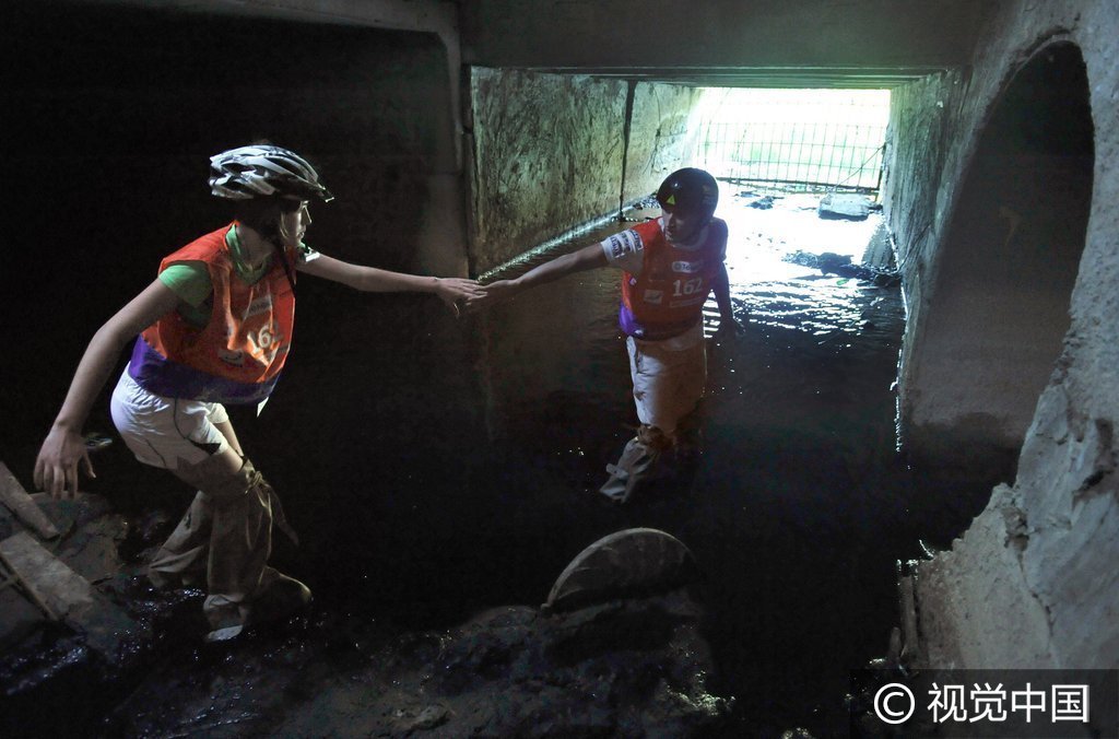 2009年6月2日，俄罗斯圣彼得堡，当地举行街区障碍竞速比赛。选手们既要爬墙又要钻下水道，忙得不亦乐乎。