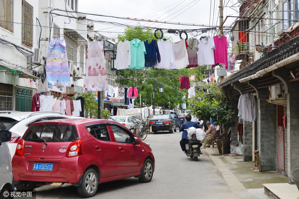 图为衣服直接挂在缠绕的电线上，十分危险。