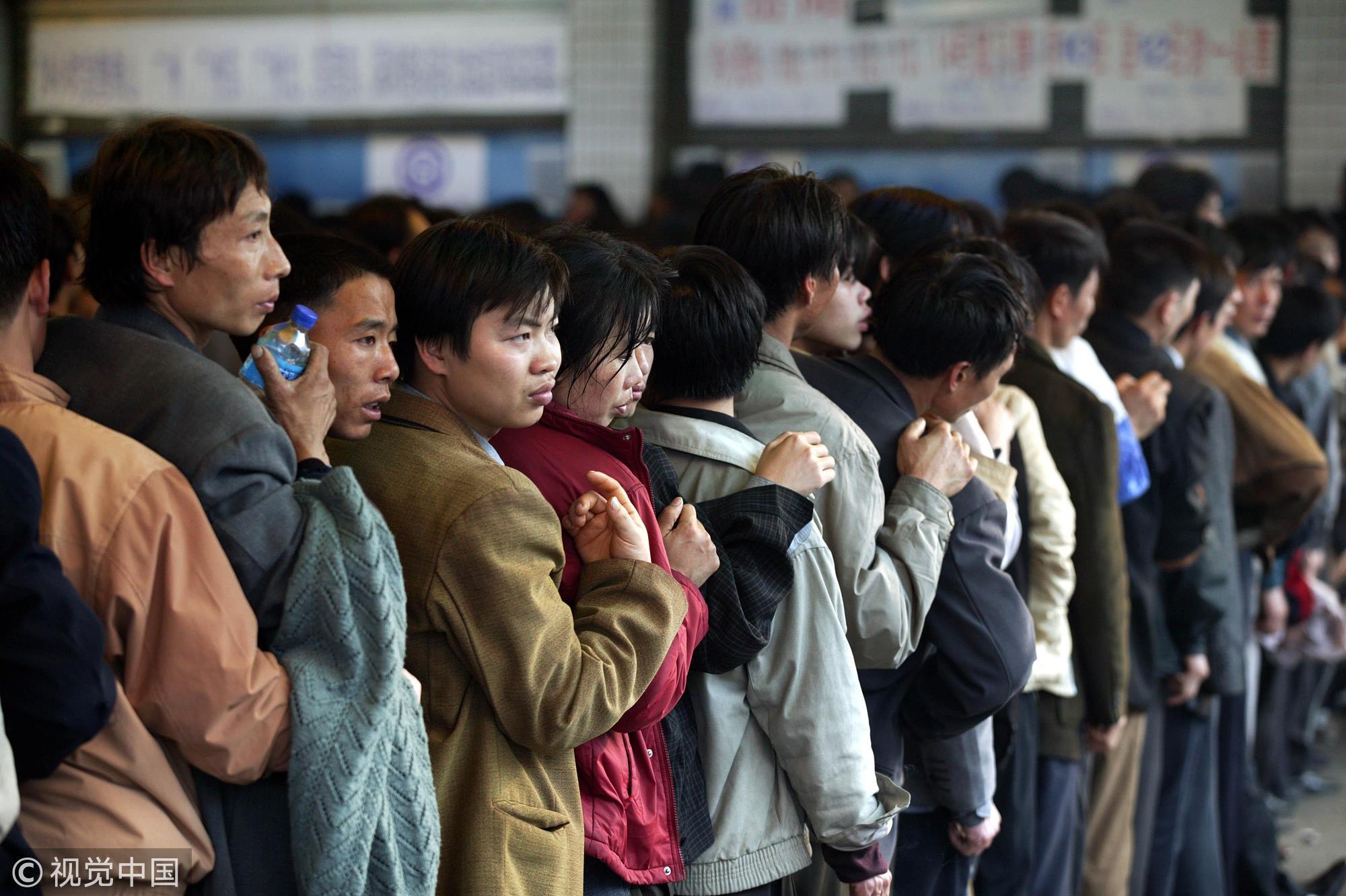 2004年1月9日，春运开始后，广东佛山火车站人如潮涌。车站内拥挤但秩序井然的购票人龙。图/视觉中国