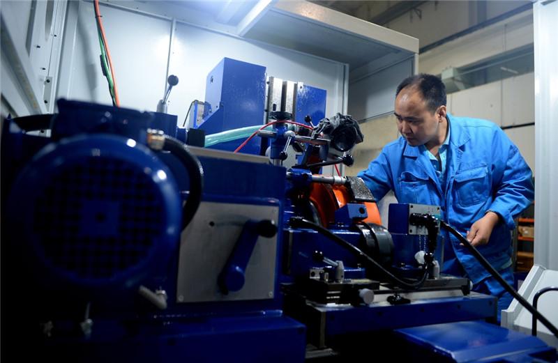 秦川机床工具集团公司装配车间的工作人员正在维护数控机床(8月10日摄