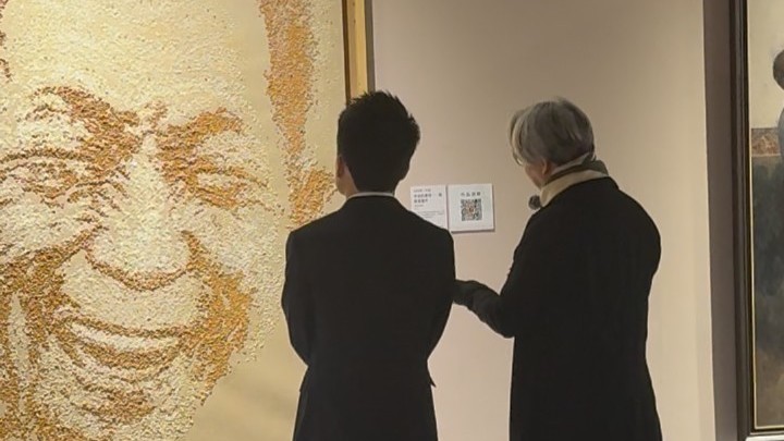 北京国际美术双年展上，董宇辉在稻米制作的袁隆平画像作品前驻足致敬